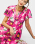 Woman wearing a vibrant floral dress on a white background