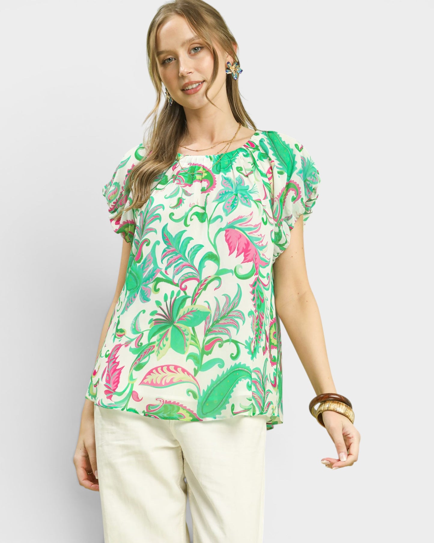 Woman wearing a colorful floral blouse against a white background