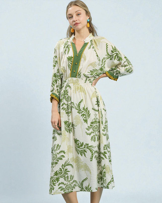 Woman wearing a green and white floral dress on a light blue background