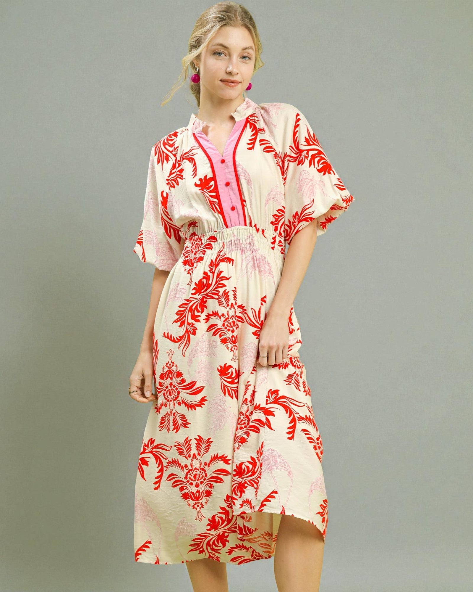 Woman wearing a red and white floral dress on a gray background
