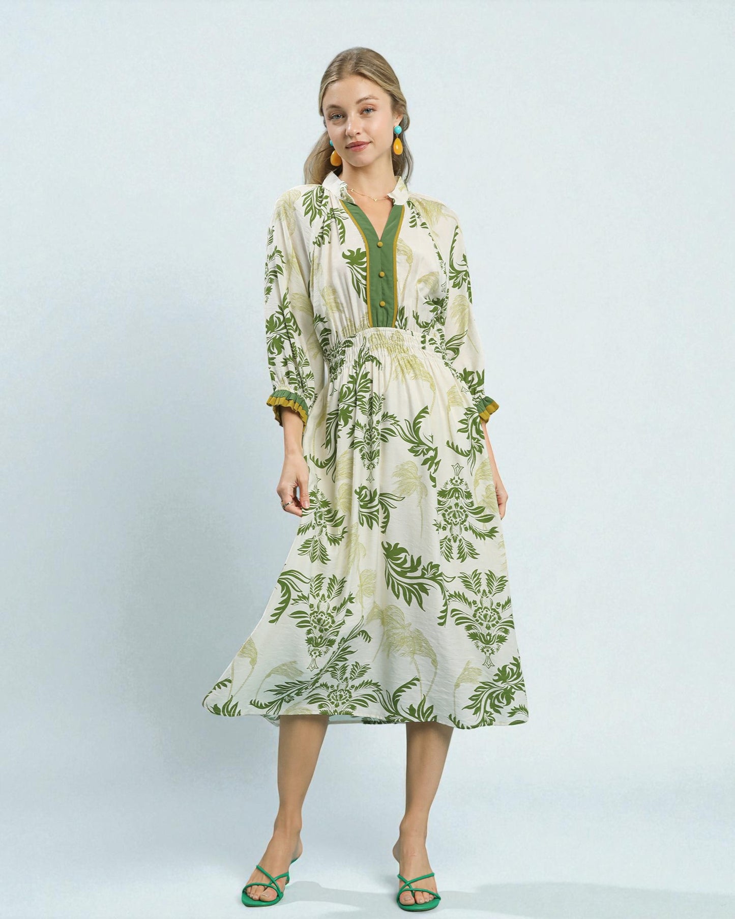 Woman wearing a green and white floral dress on a light gray background