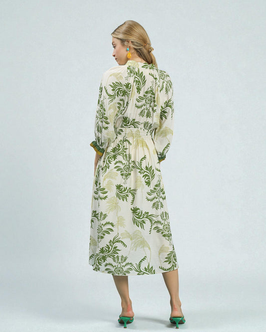 Woman wearing a floral dress with green leaves on a white background