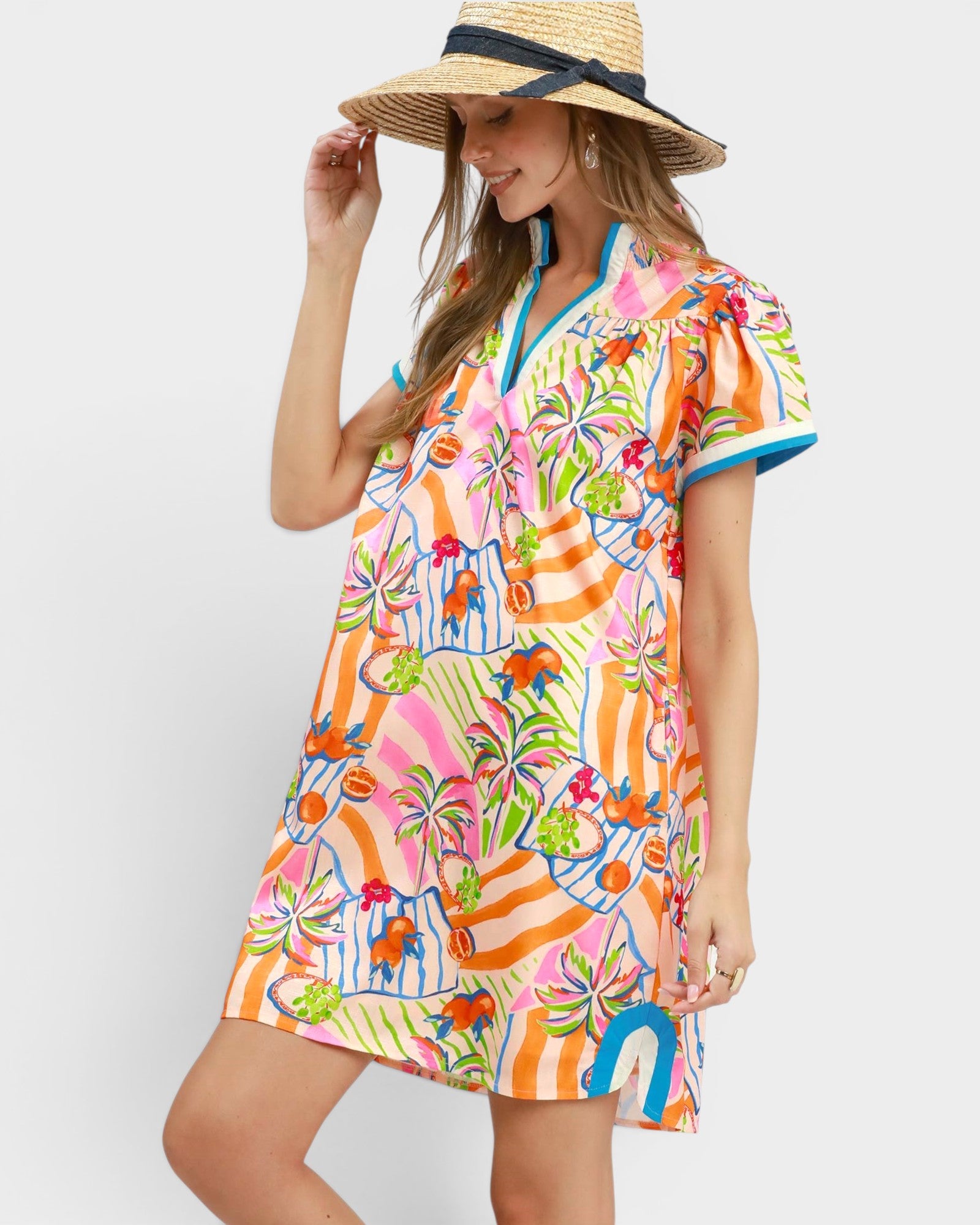 Woman wearing a colorful floral dress with a straw hat on a white background