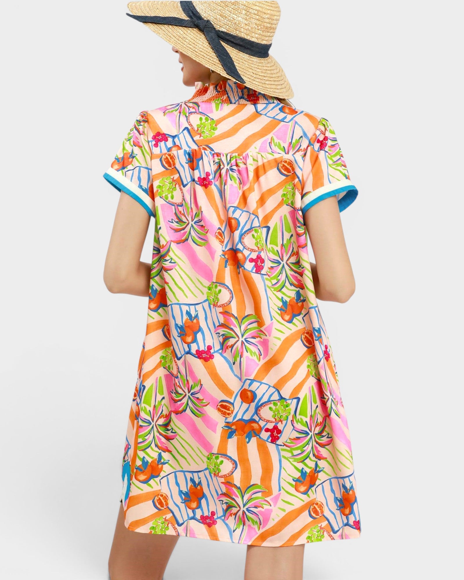 Woman wearing a colorful patterned dress with a straw hat on a white background