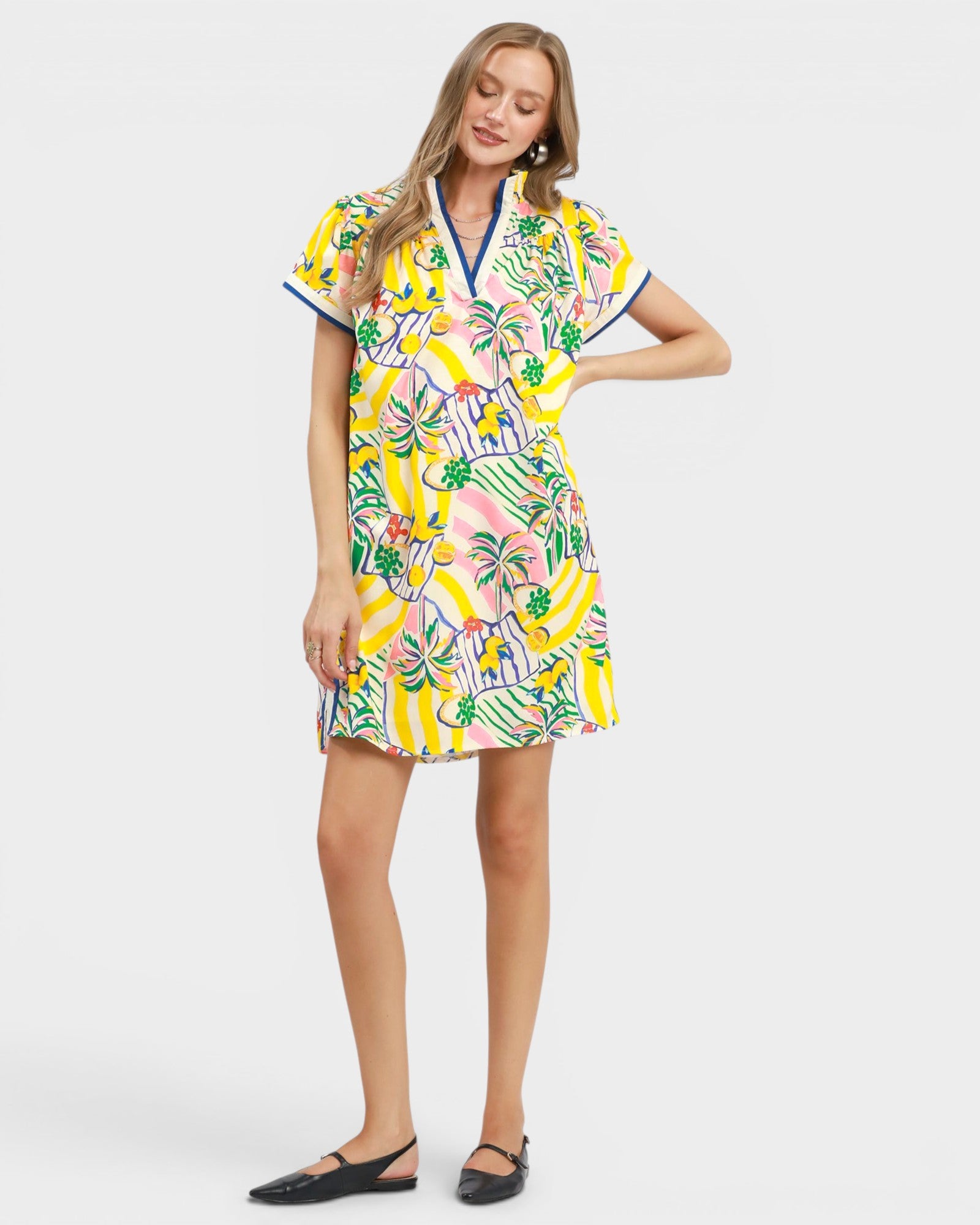 Woman wearing a colorful tropical pattern dress on a white background