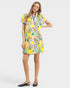 Woman wearing a colorful tropical pattern dress on a white background
