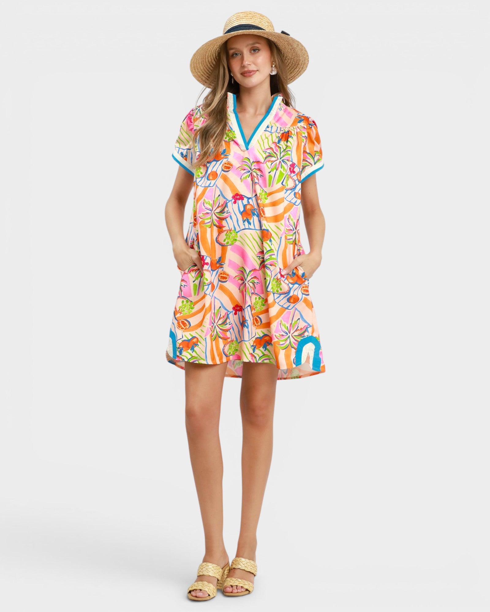 Woman wearing a colorful dress with a straw hat on a white background
