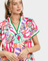 Woman wearing a colorful floral dress with a white background