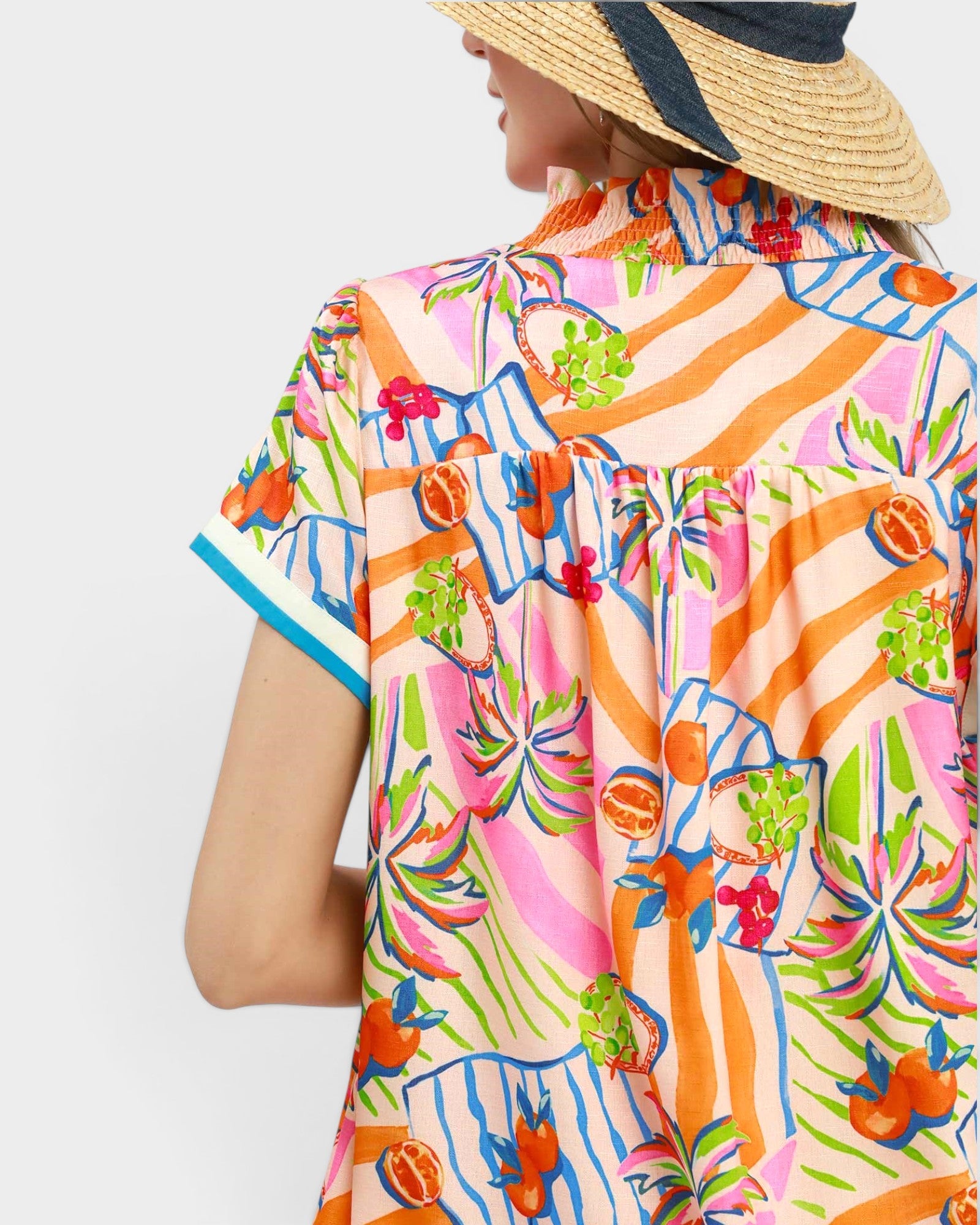 Person wearing a colorful tropical shirt with a white background