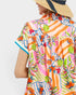 Person wearing a colorful tropical shirt with a white background