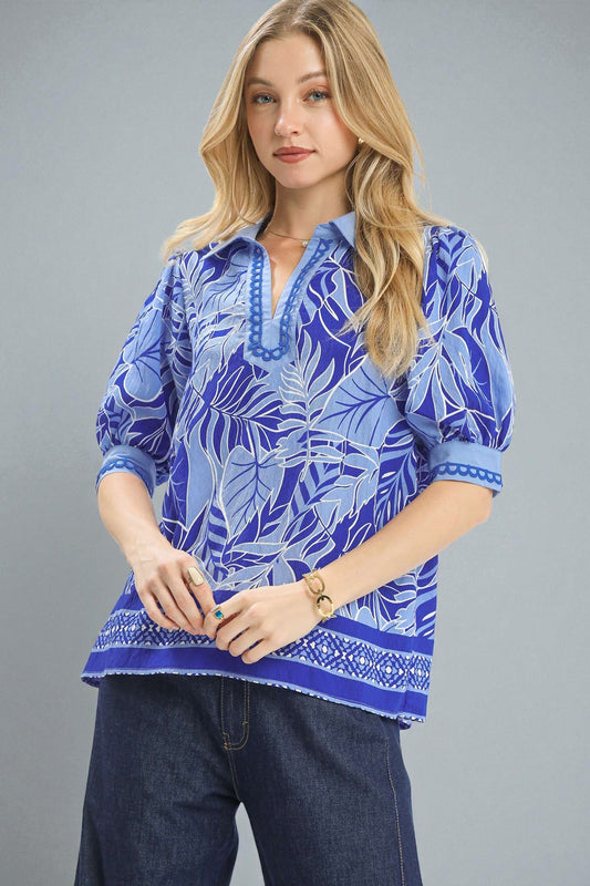 Woman wearing a blue patterned top against a gray background