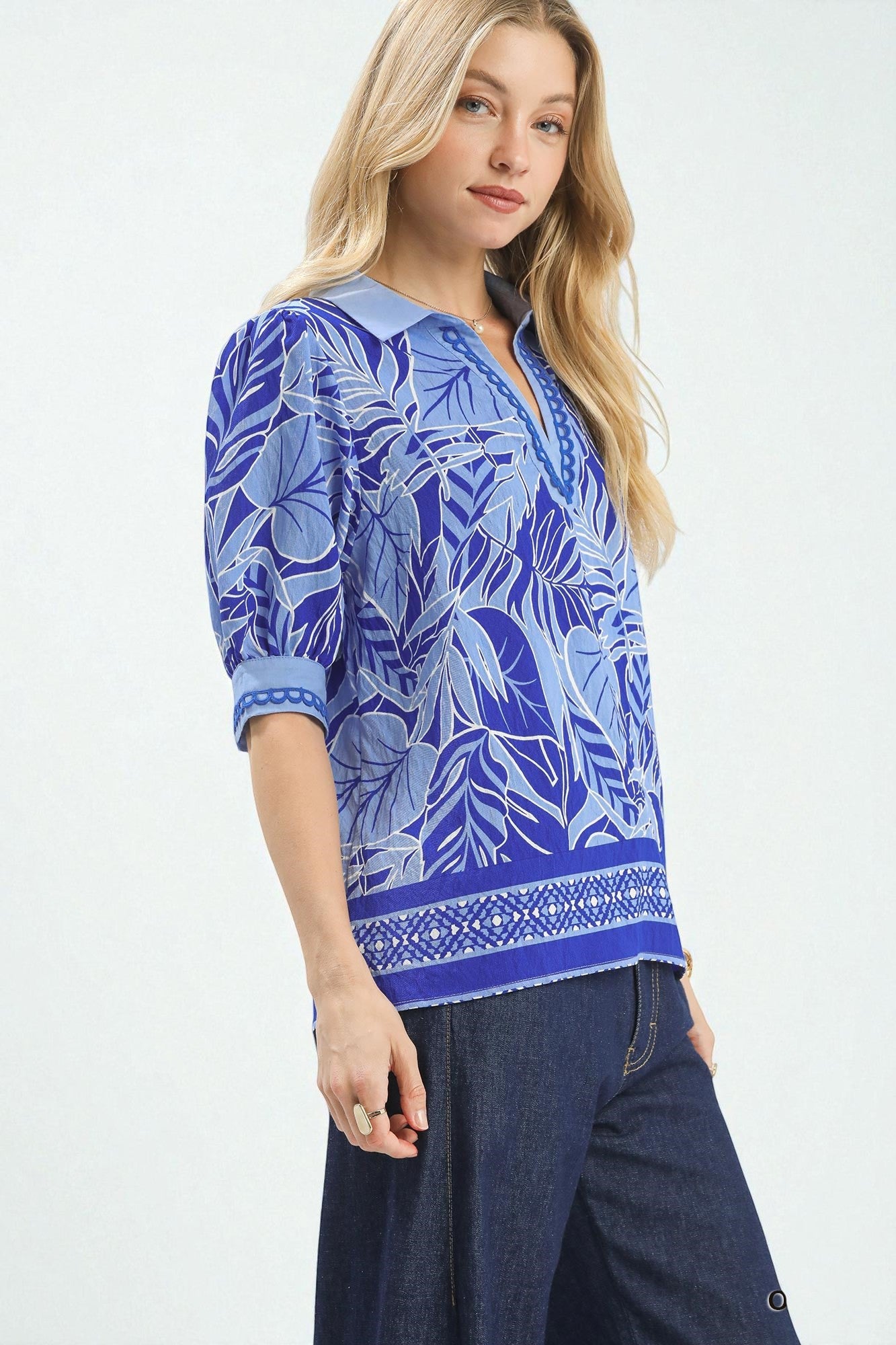 Woman wearing a blue patterned top with a white background
