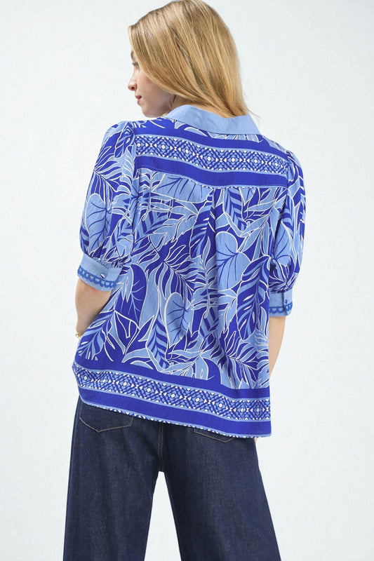 Woman wearing a blue patterned shirt with a white background