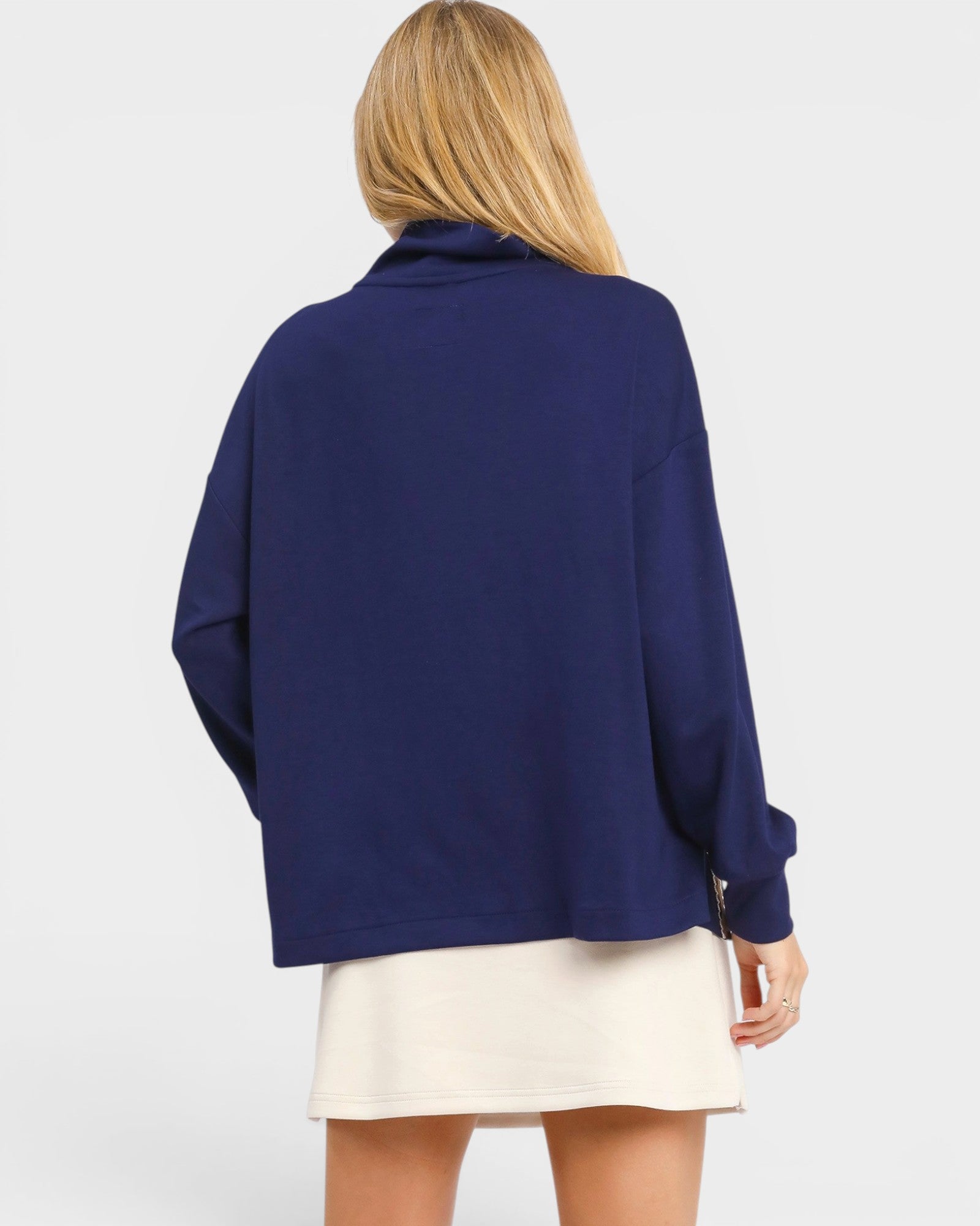 Person wearing a blue sweater with a plain background