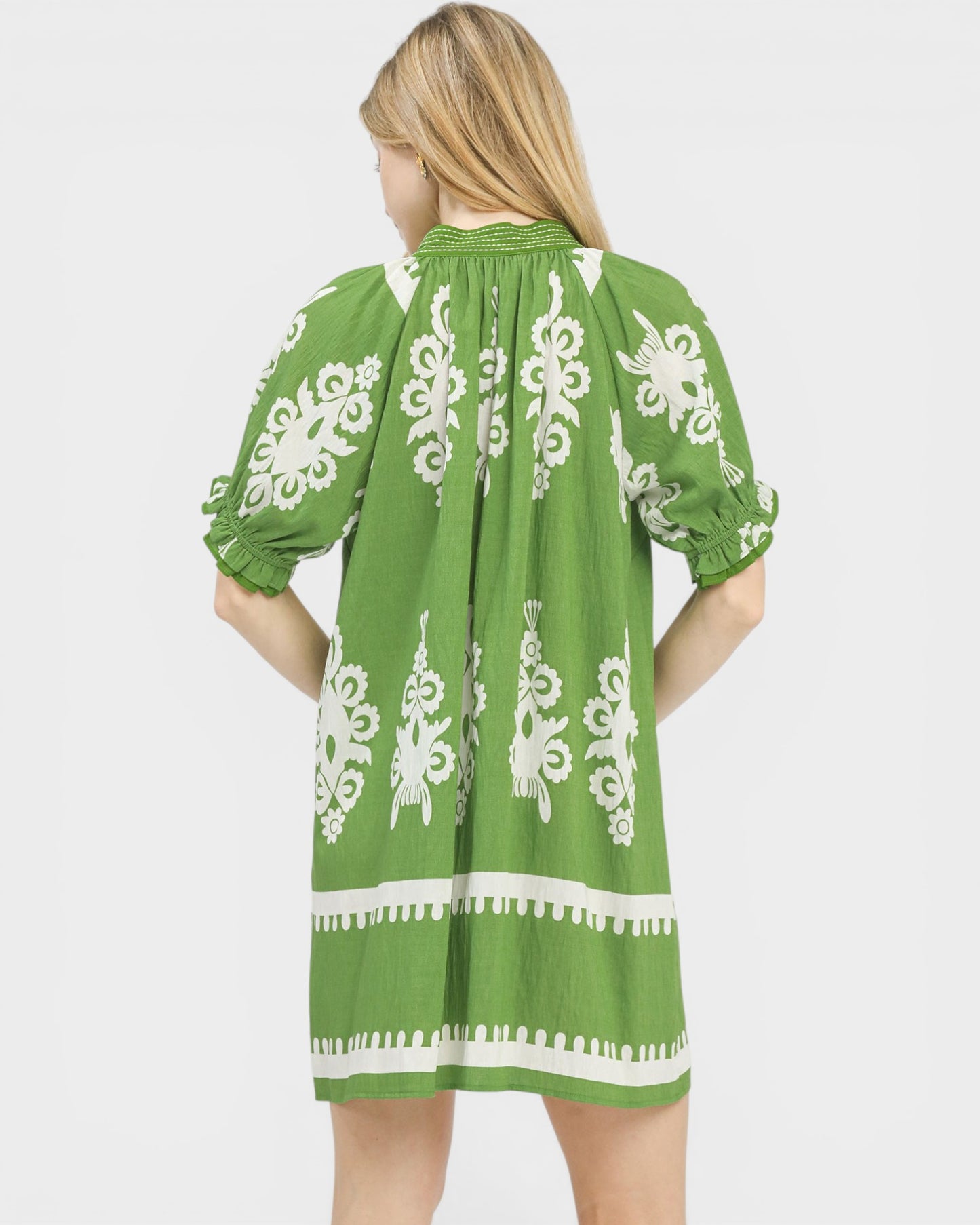 Green dress with white patterns on a plain background