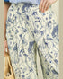 Person wearing a floral patterned dress with blue and white flowers on a beige background