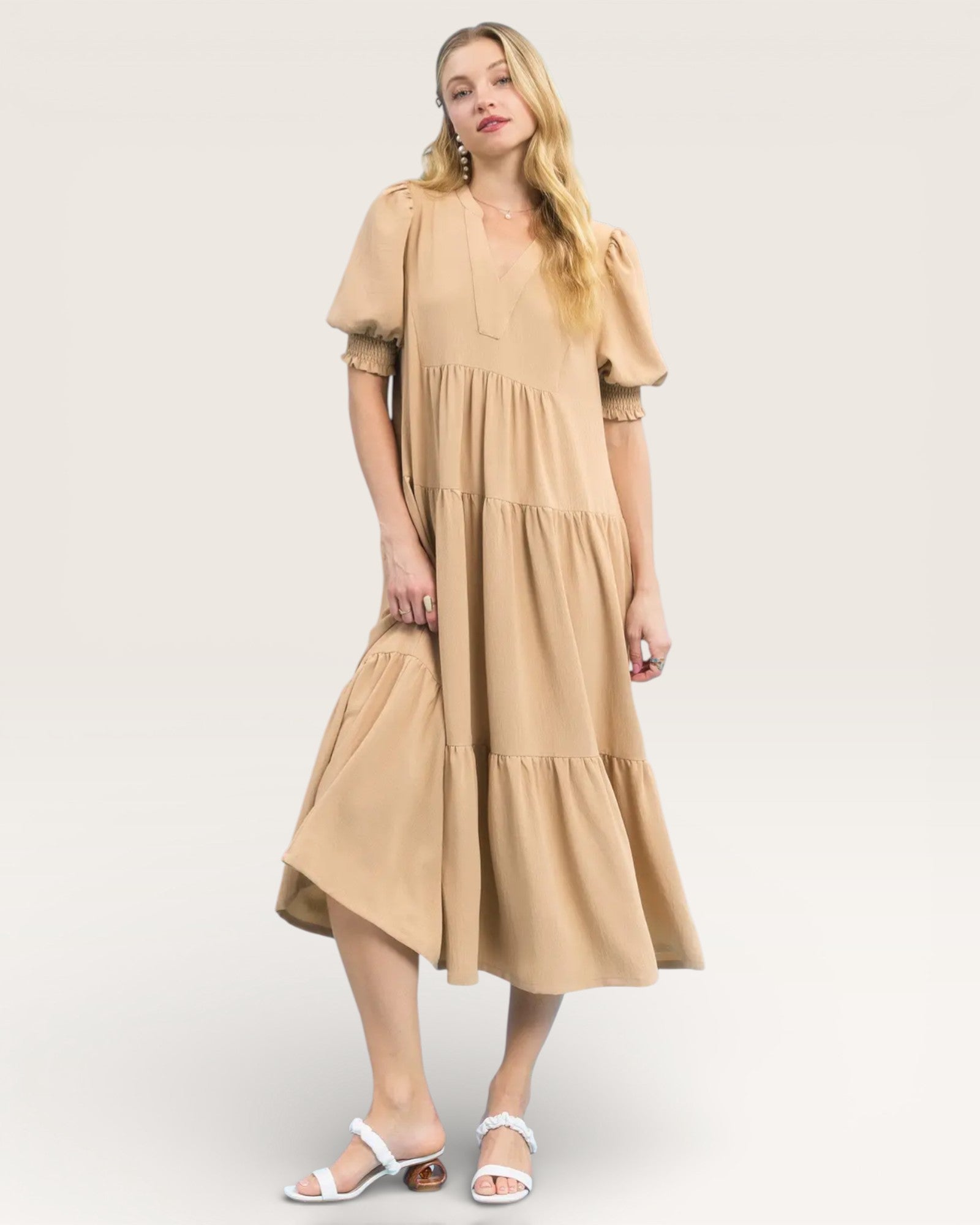 Woman wearing a beige dress on a white background