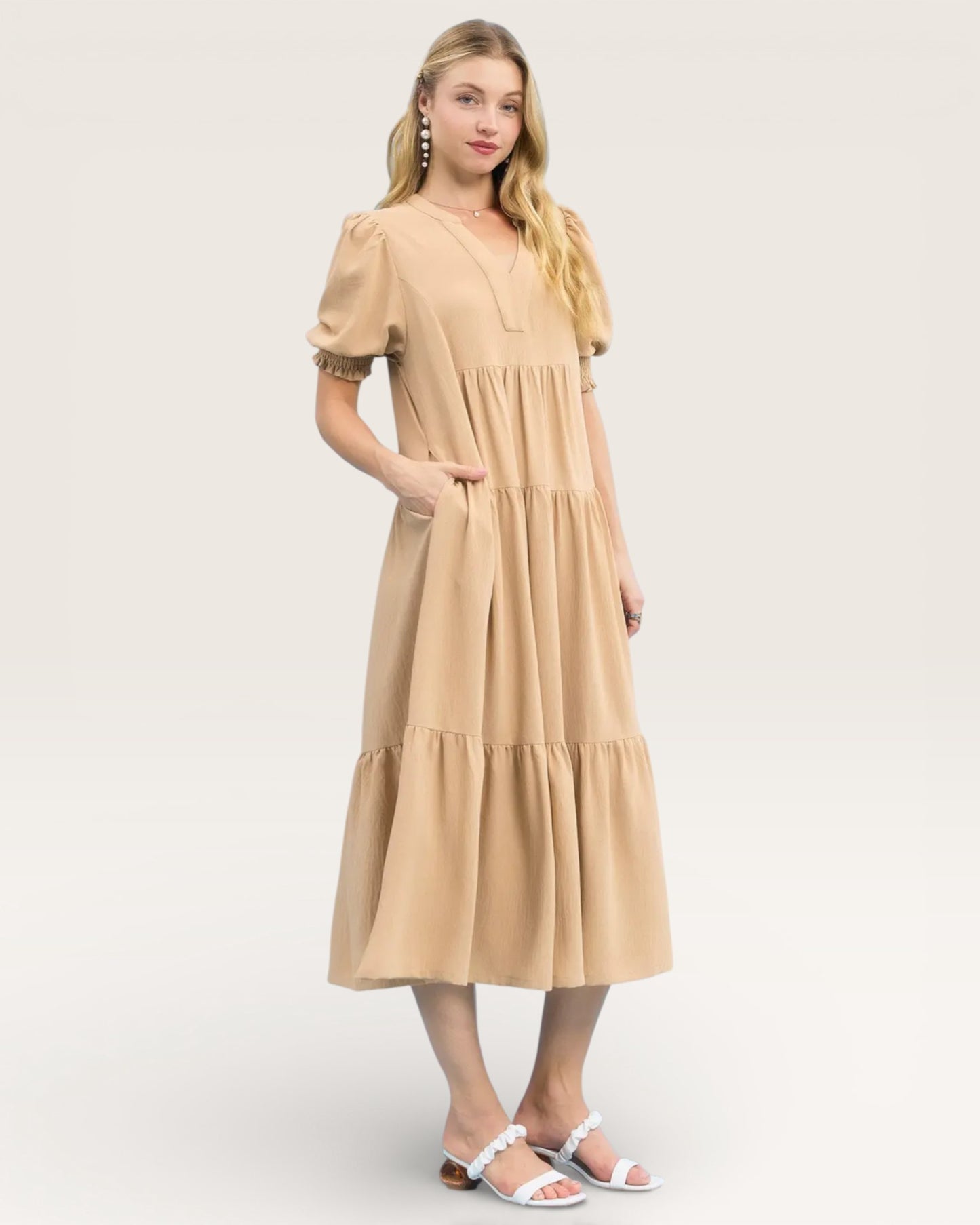 Woman wearing a beige dress on a white background