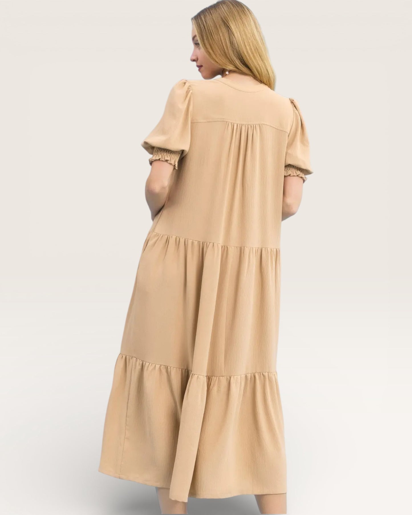 Woman wearing a beige dress on a white background