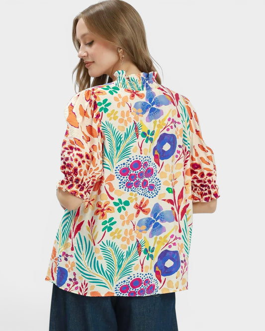 Woman wearing a colorful floral blouse on a white background