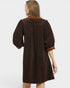 Brown dress with embroidered details on a white background