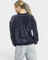 Person wearing a dark blue velour sweatshirt and light blue jeans on a white background