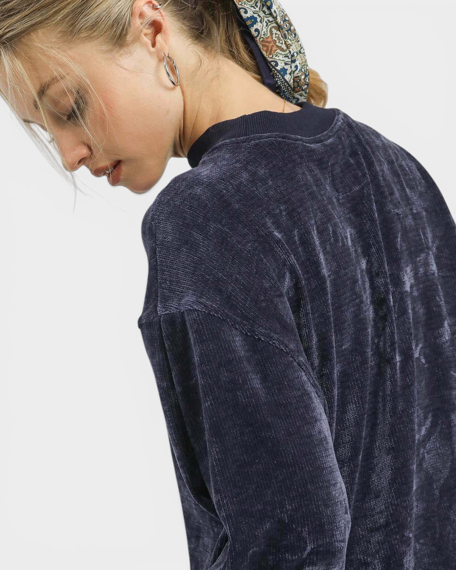 Person wearing a dark blue textured sweater on a white background