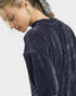 Person wearing a dark blue textured sweater on a white background