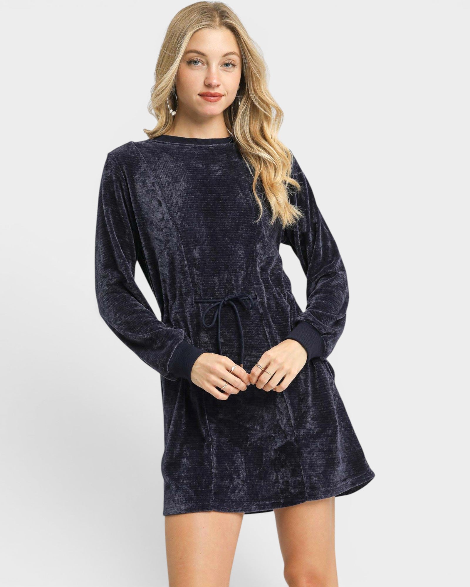 Woman wearing a navy velvet dress on a white background
