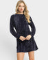 Woman wearing a navy velvet dress on a white background
