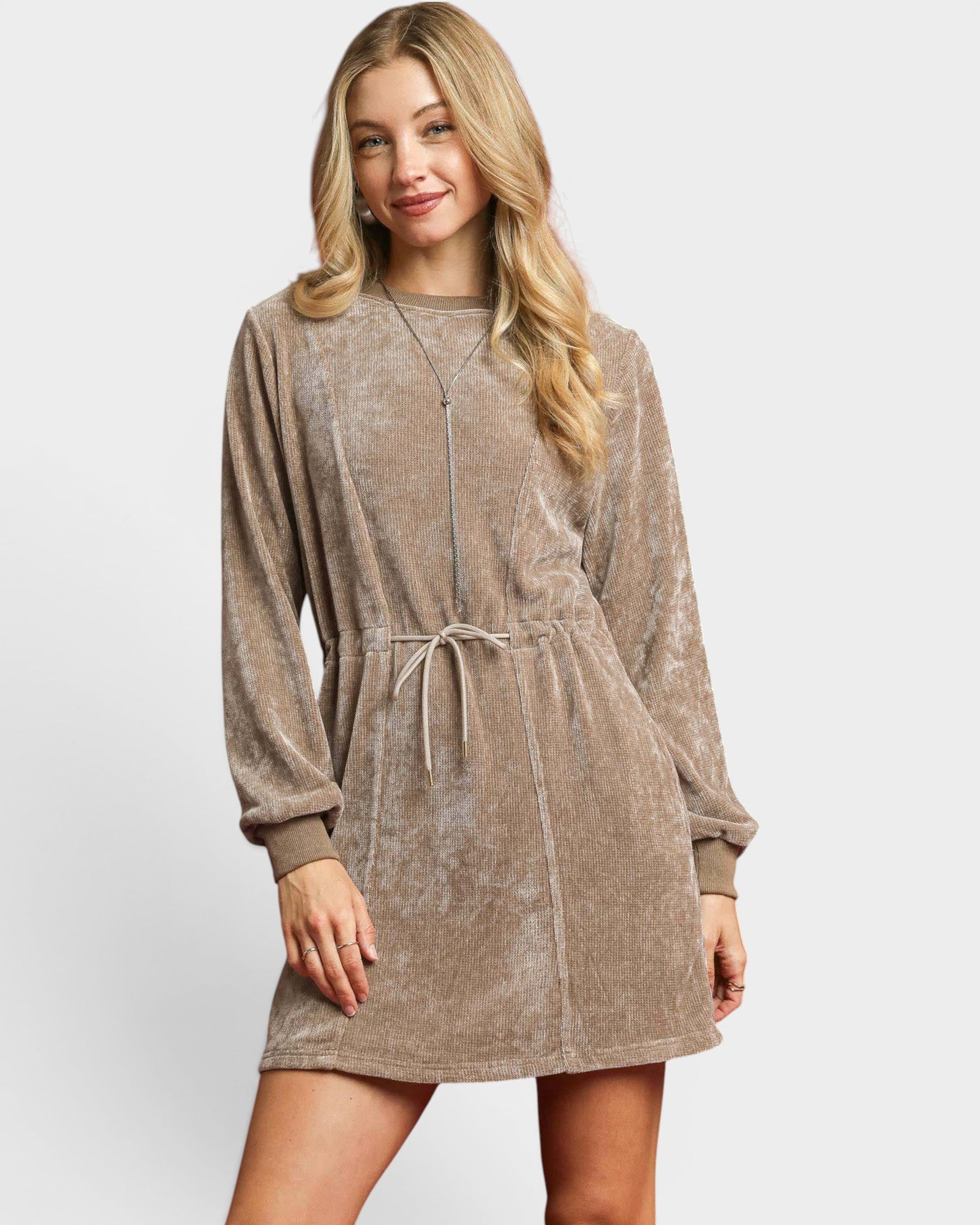 Woman wearing a brown velour dress on a white background