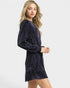 Woman wearing a navy blue long-sleeve dress on a white background