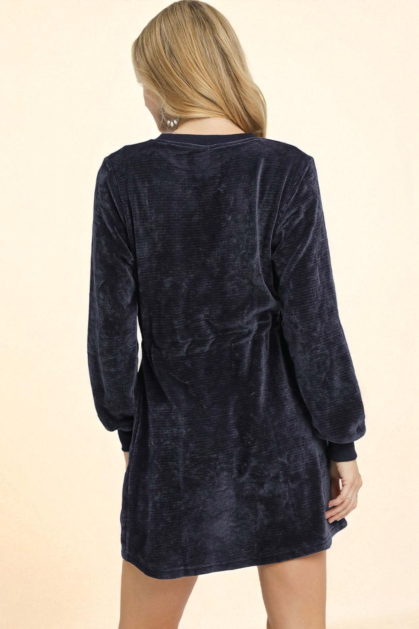 Navy blue velour dress worn by a person on a beige background