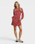 Woman wearing a red dress with pockets on a white background