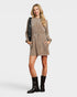 Woman wearing a brown dress with black boots on a white background