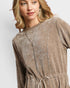 Woman wearing a brown velour dress on a white background