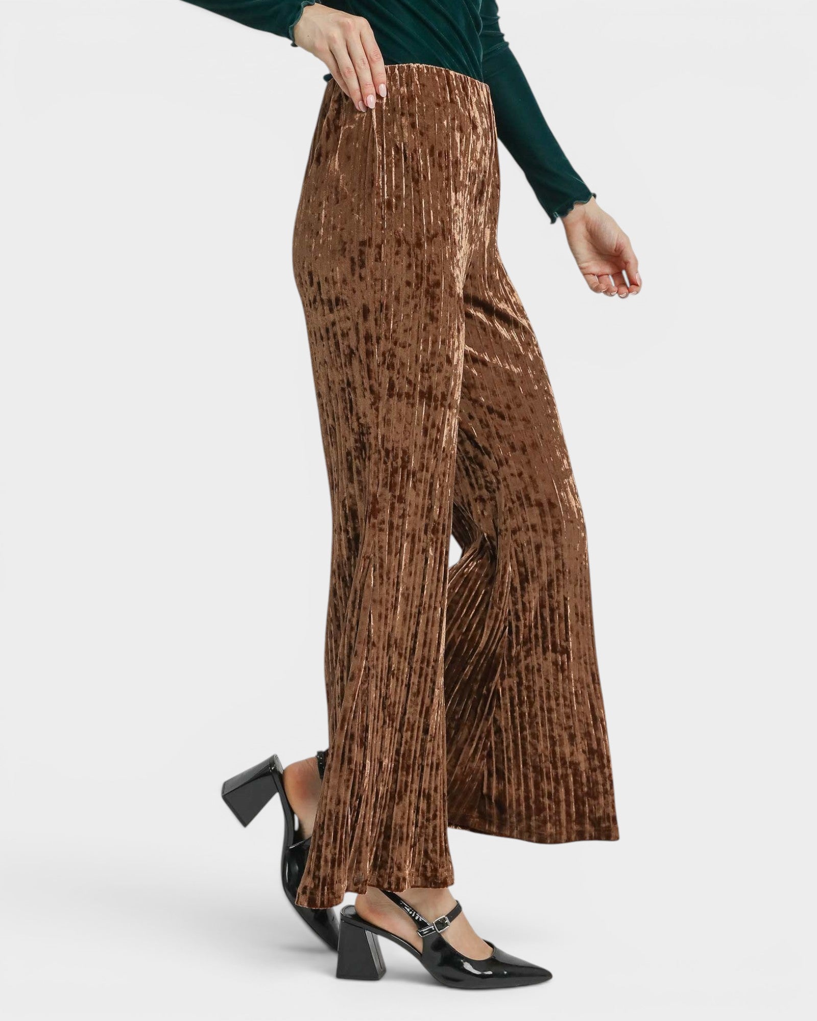 Brown pleated pants worn by a person on a white background