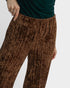Brown patterned pants worn by a person on a light gray background