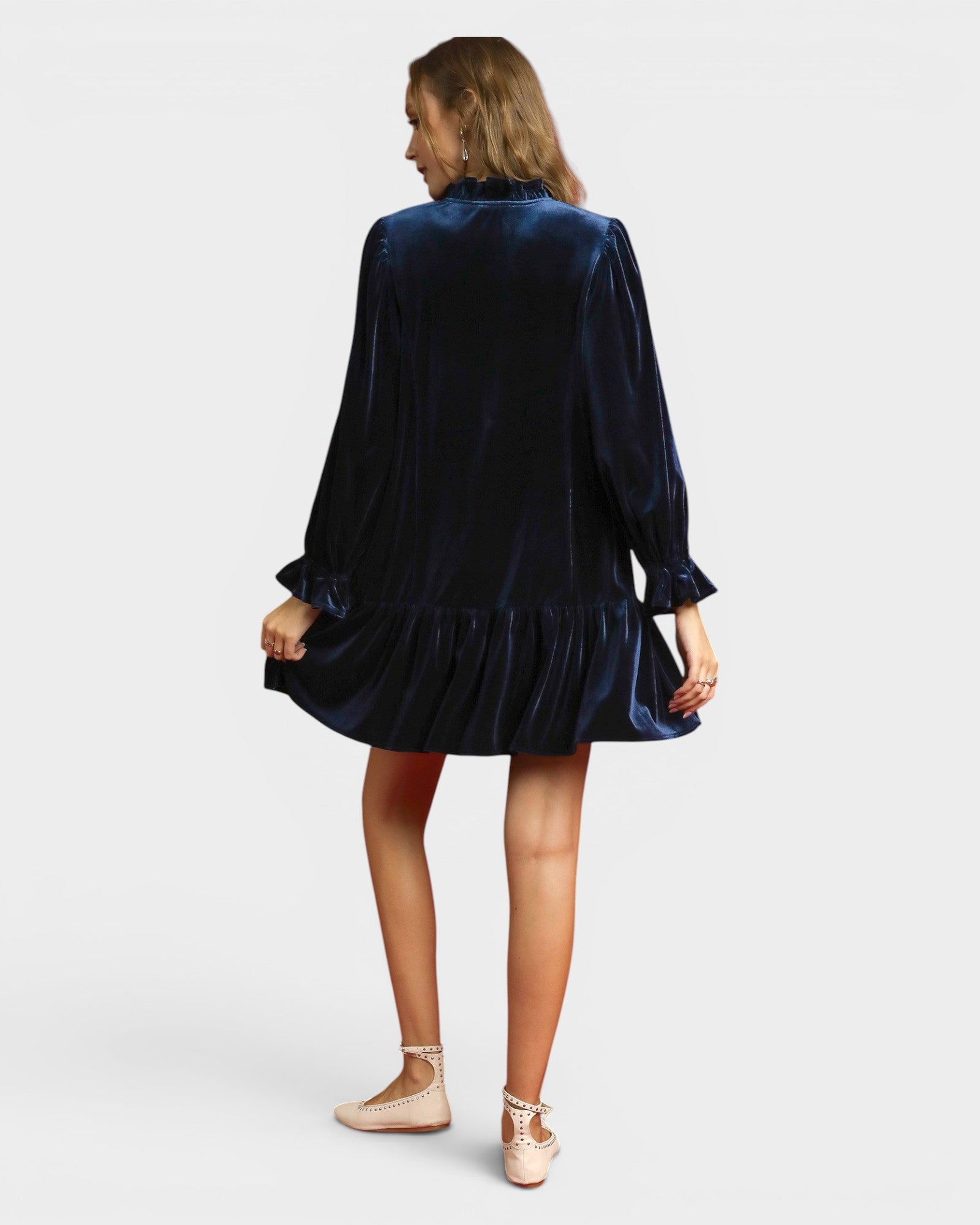 Woman wearing a navy velvet dress on a white background