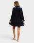 Woman wearing a navy velvet dress on a white background