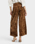 Brown crushed velvet pants worn by a person on a white background