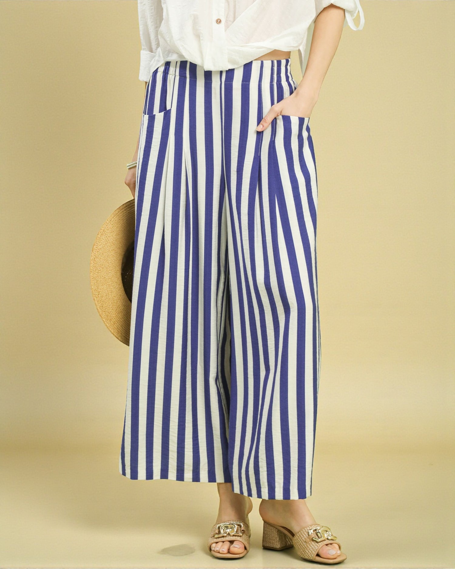 Person wearing blue and white striped pants on a beige background