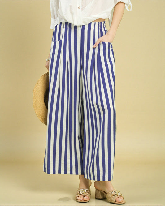 Person wearing blue and white striped pants on a beige background