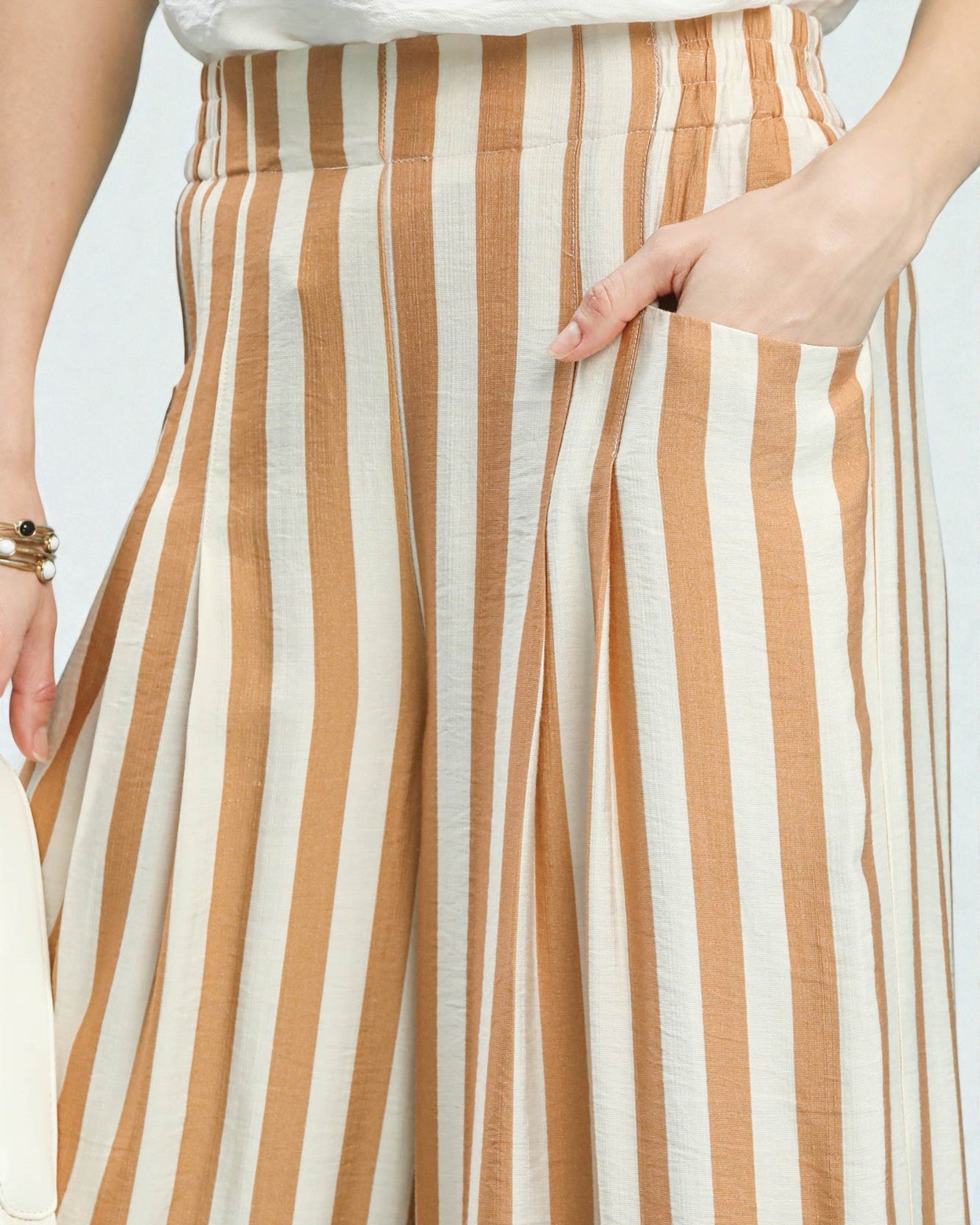 Close-up of a person wearing a brown and white striped skirt.