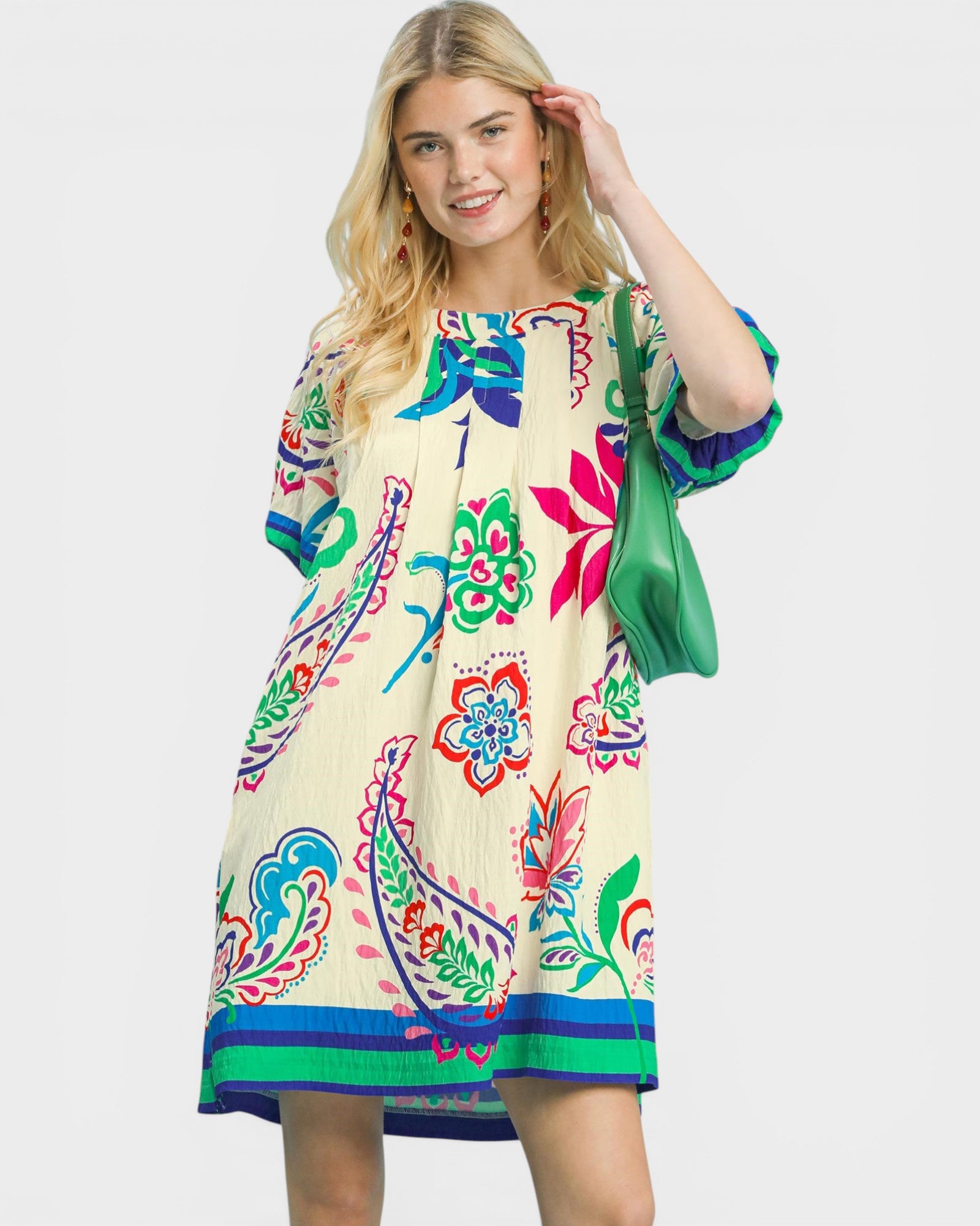 Woman wearing a colorful dress with floral patterns on a white background