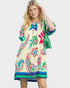 Woman wearing a colorful dress with floral patterns on a white background