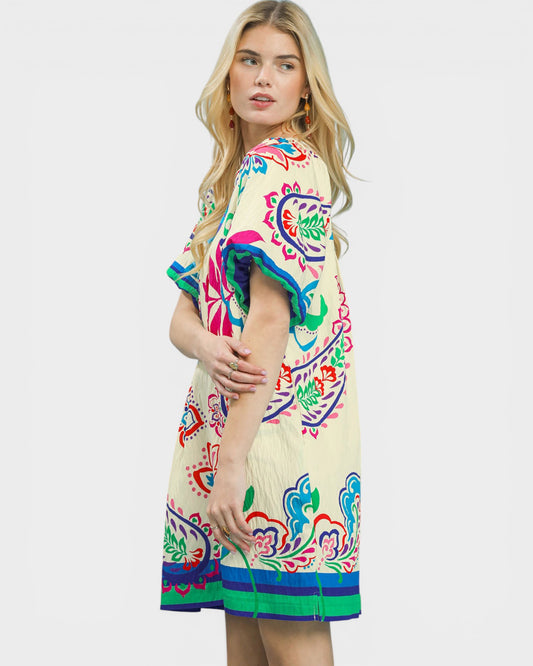 Woman wearing a colorful dress with a floral pattern on a white background