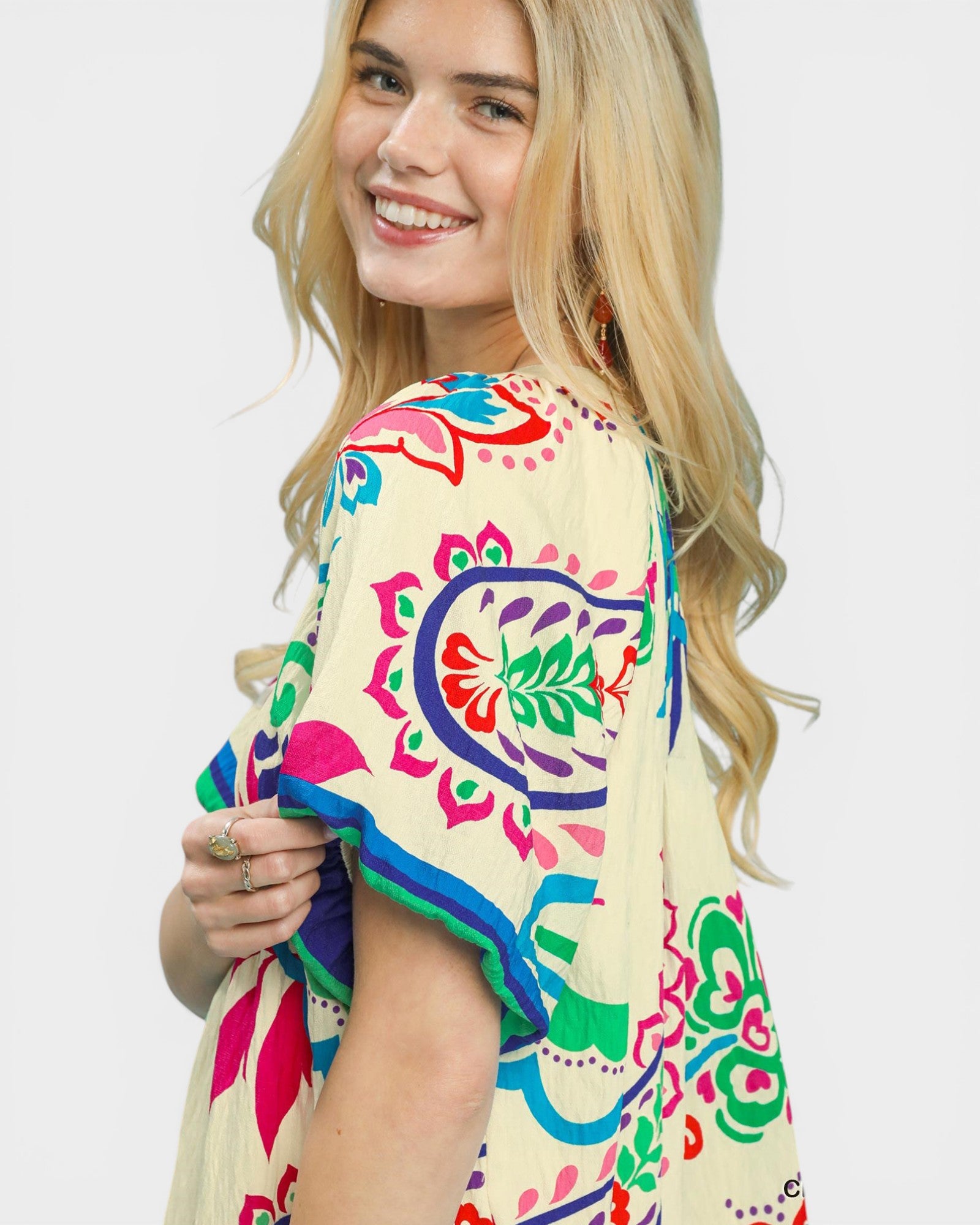 Woman wearing a colorful patterned top on a white background