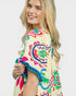 Woman wearing a colorful patterned top on a white background