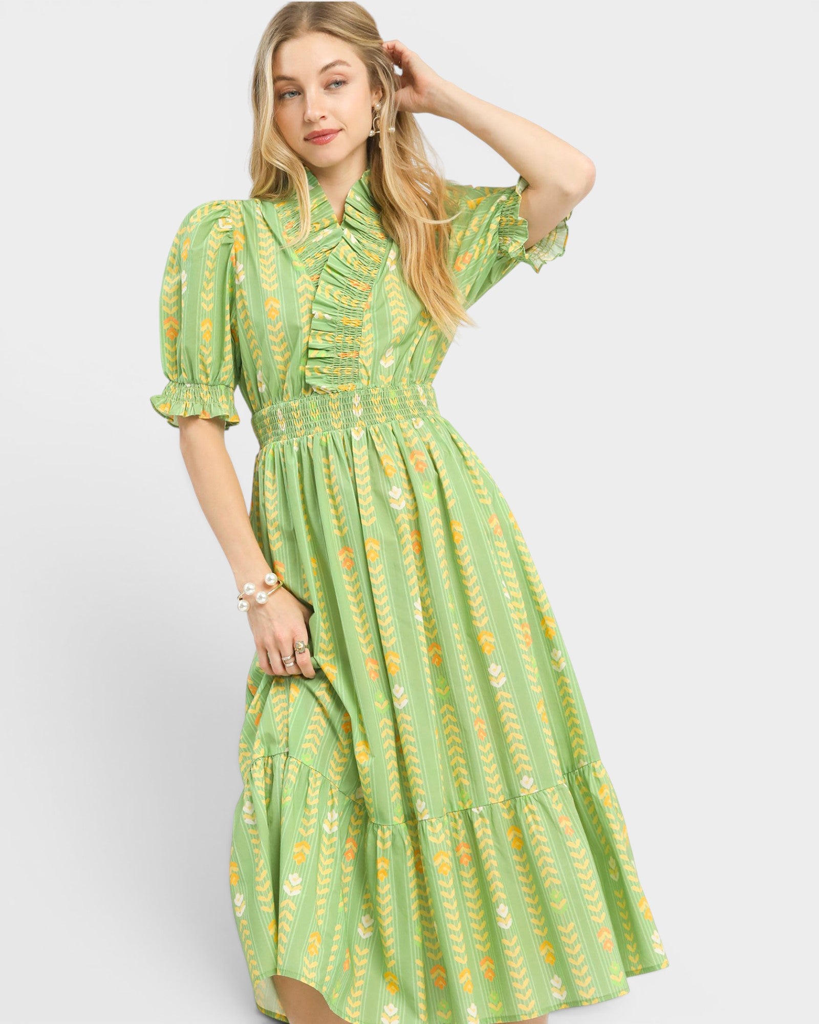 Woman wearing a green dress with a pattern on a white background